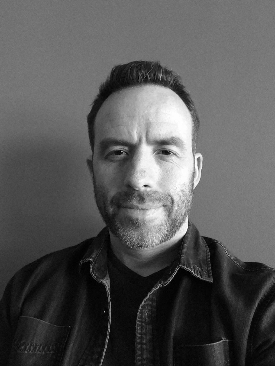 black and white headshot of a man with a short beard