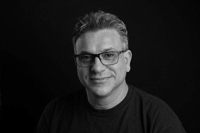 black and white headshot of a man with glasses