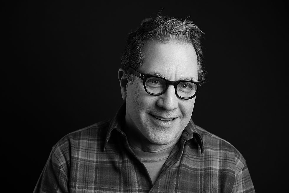 black and white headshot of a man with glasses and a collared shirt